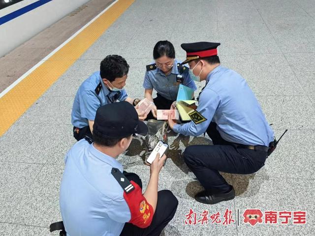 列车工作人员在站台交接旅客遗失物品。通讯员 吴志琼 摄