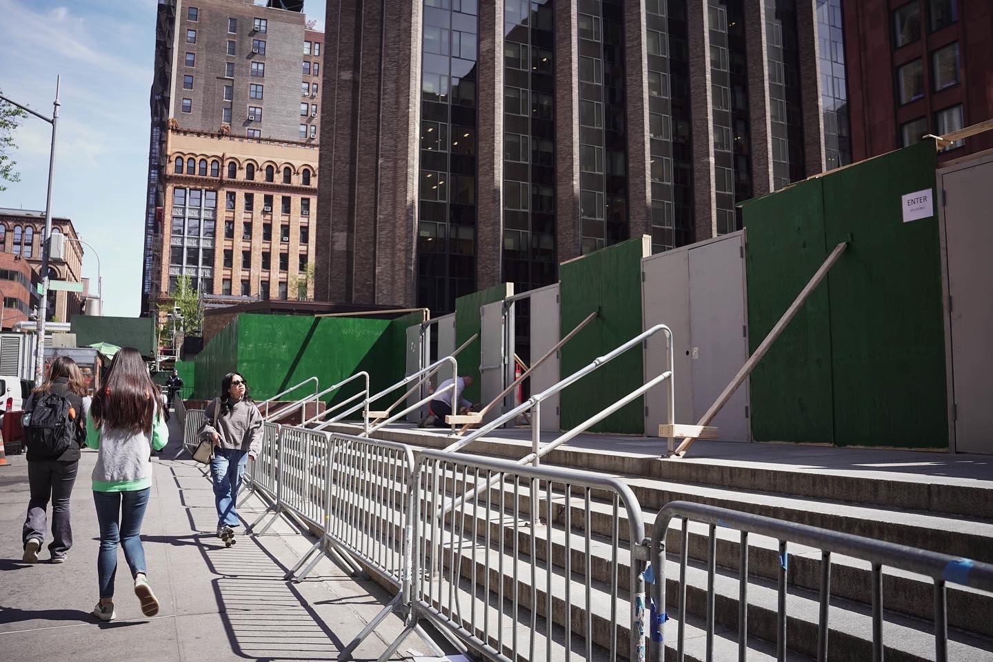当地时间2024年4月26日，学生经过封锁纽约大学古德尔广场的木板墙。