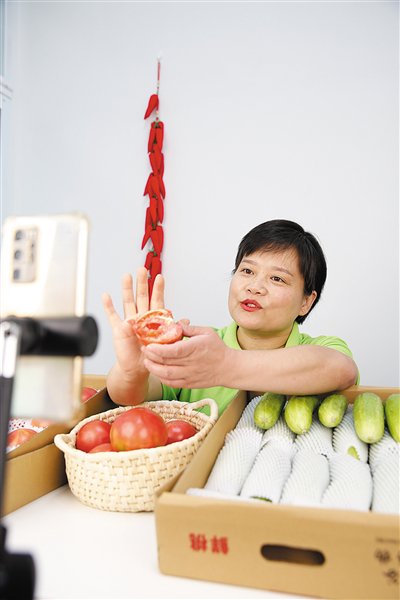 王丹正在直播带货，推介西红柿和黄瓜。本版图片/马平川 摄