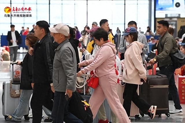 　　4月29日，在乌鲁木齐站候车大厅，旅客有序前往检票口，准备进站 。记者陈岩摄