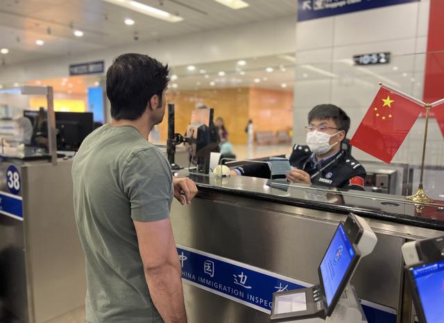 上海移民管理警察为旅客办理边检查验手续。黄波 摄