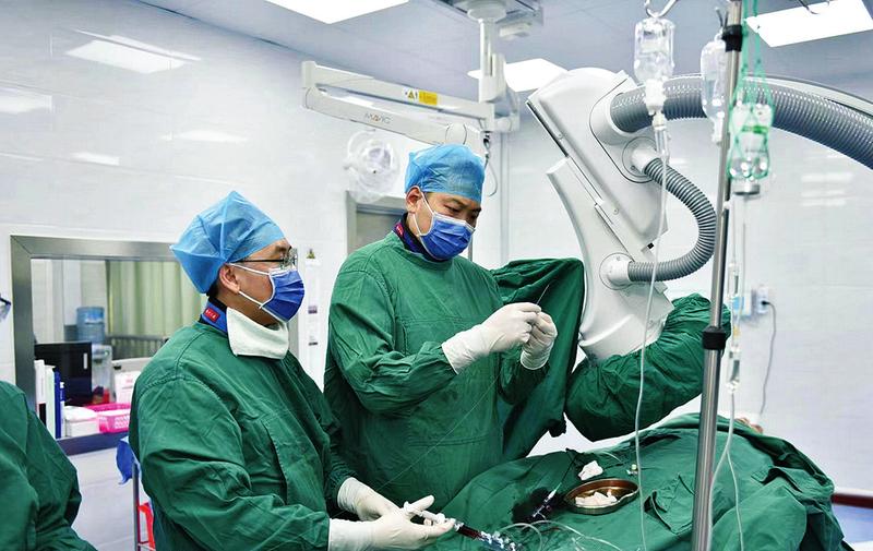     ▲中国医学科学院阜外医院深圳医院派驻隆安县人民医院的医生杨大浩（右）正在进行手术。