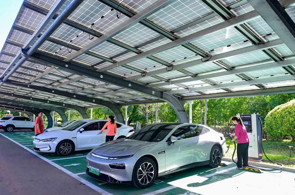 2023年7月8日，市民在鄂尔多斯市康巴什区公共停车场里为电动车充电。该停车场建设了棚顶光伏发电设施