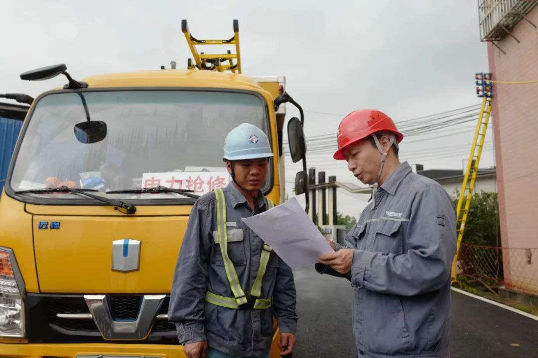 在白云区钟落潭镇光明村，广州供电局抢修人员研究复电方案。