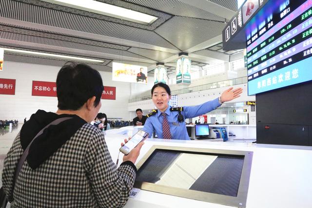 阜阳西站12306服务台工作人员为旅客提供咨询解答服务。 张续亮 图