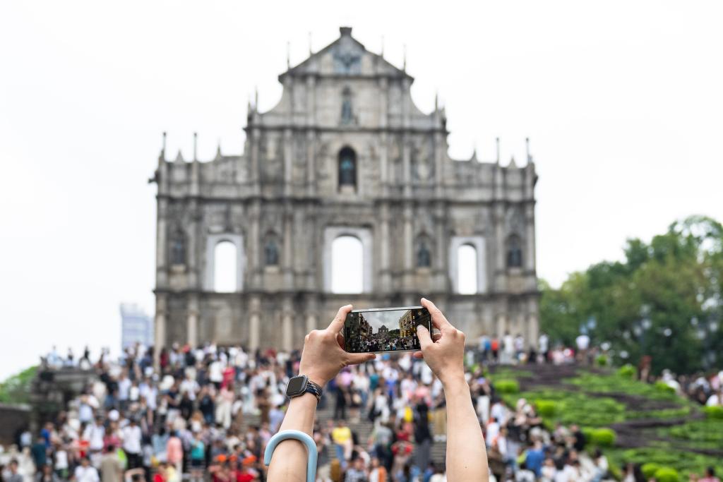 5月1日，游客在澳门大三巴牌坊前游览、拍照。新华社记者 张金加 摄