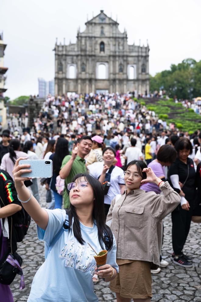 5月1日，游客在澳门大三巴牌坊前游览、拍照。新华社记者 张金加 摄
