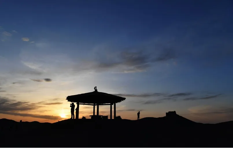 傍晚，游客在阳关拍摄大漠落日景色。新华社记者 陈斌 摄