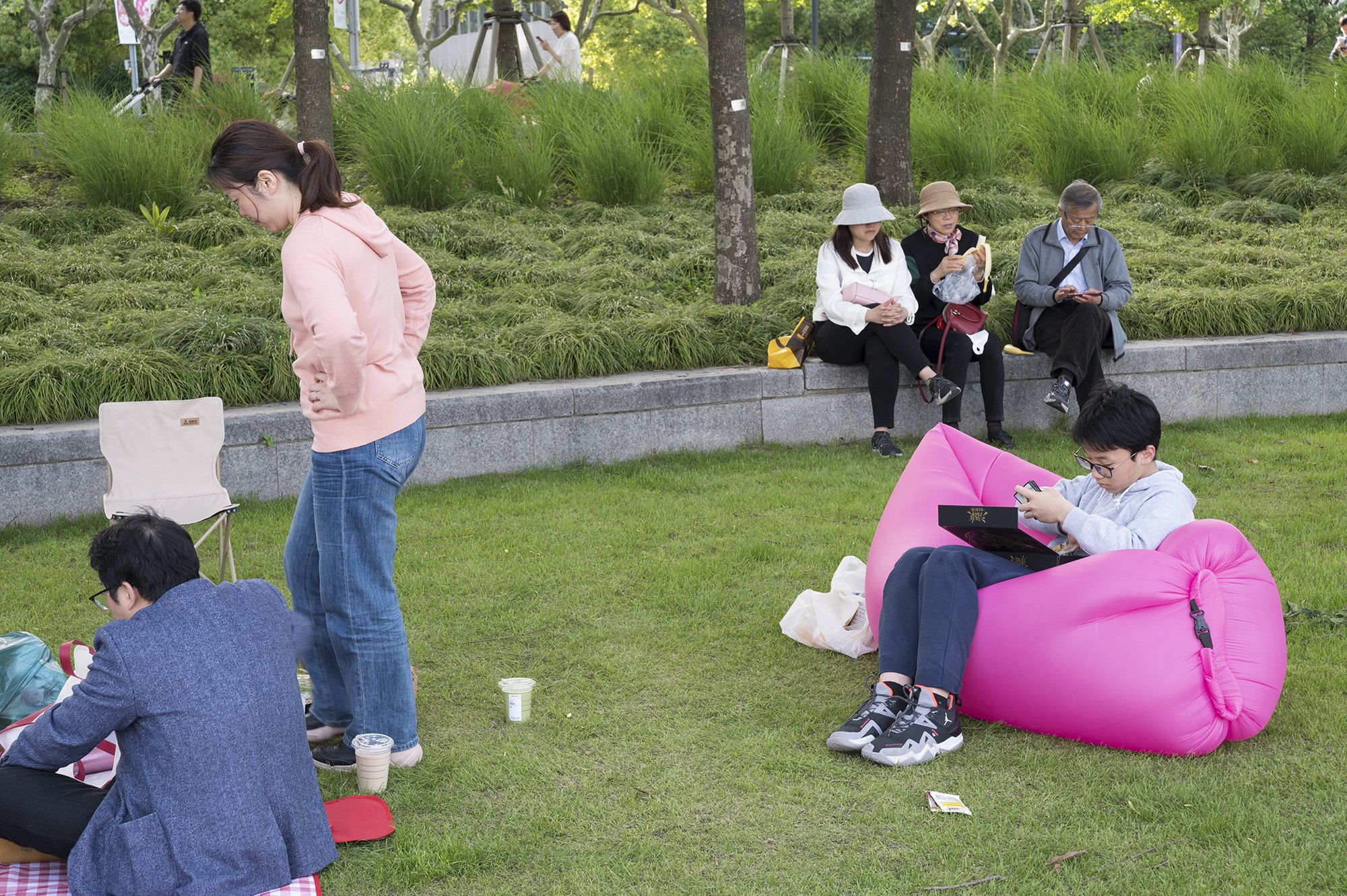 2024年5月1日，上海徐汇滨江。游人正在江边草坪上野餐休憩。澎湃新闻记者 吴栋 图
