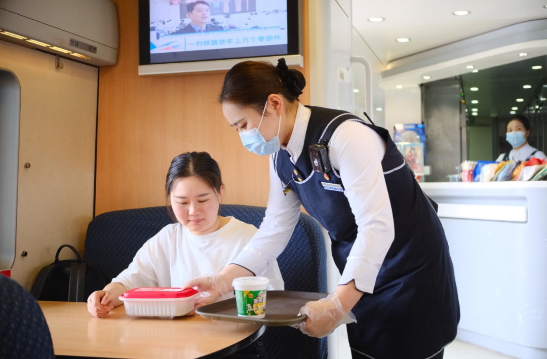 华铁旅服公司青年职工为旅客配送平价优质餐食。（王圣凯/摄）