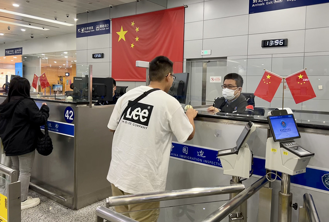 上海移民管理警察为旅客办理边检查验手续。 黄波 摄