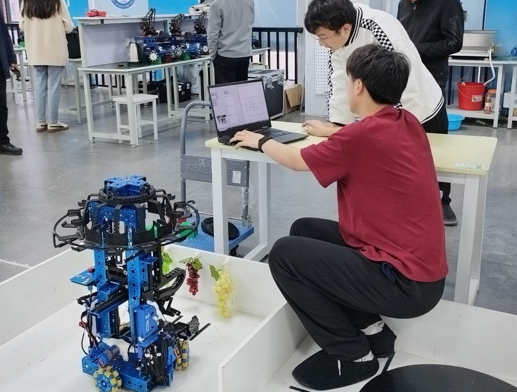 白金科（图中身着白色上衣）和同学在调试机器人。新华社记者 牛少杰 摄