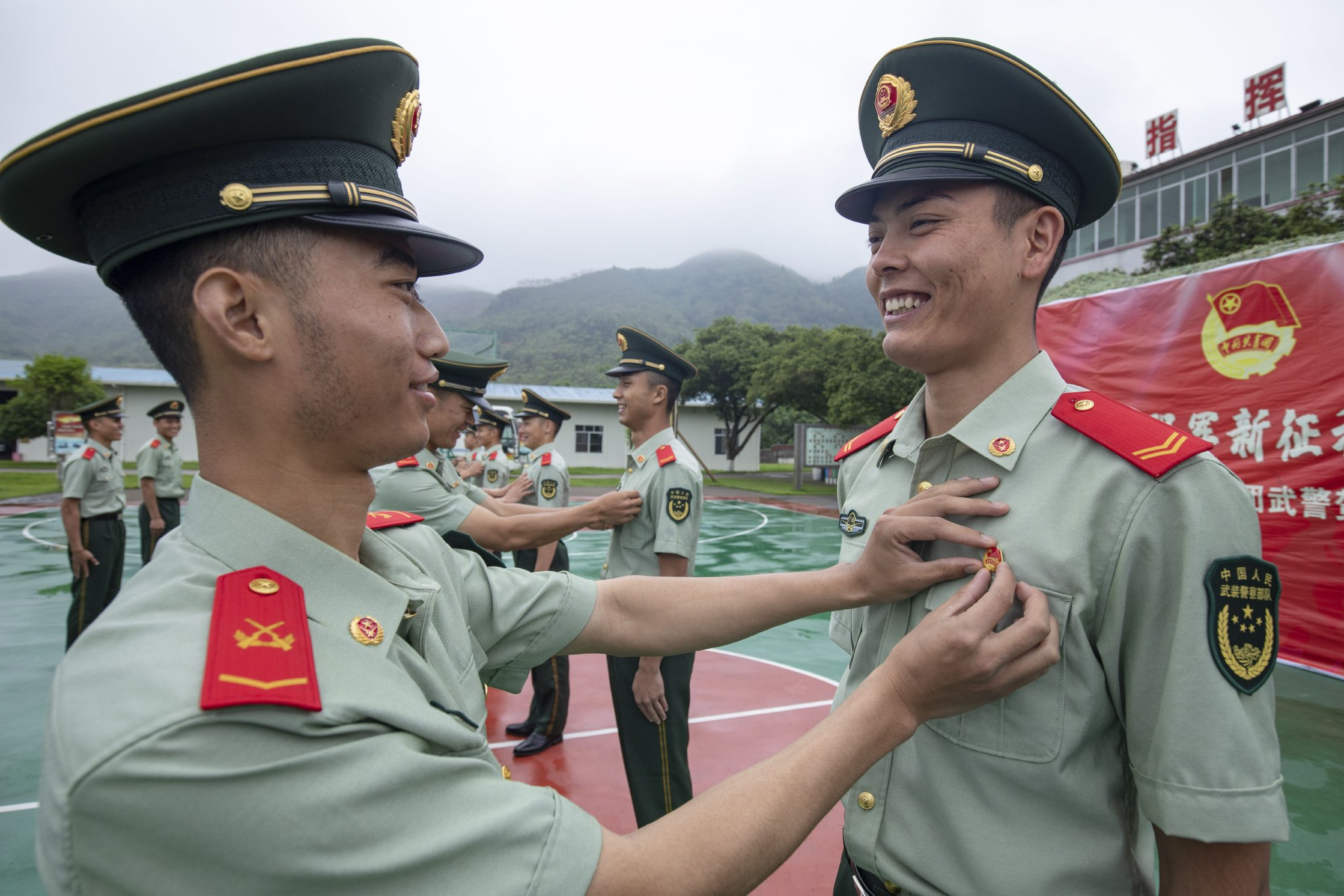 老团员为新团员佩戴团徽.武警官兵在团旗面前庄严宣誓.(张毕海 摄)