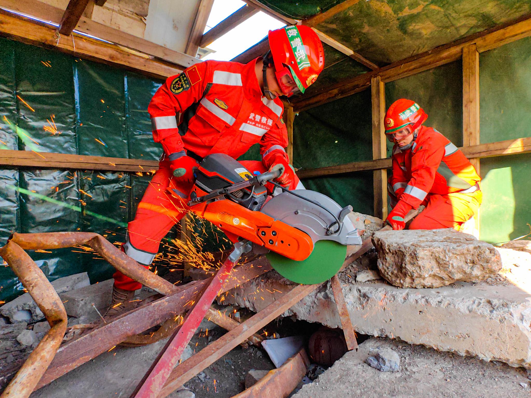 武警官兵在地震救援演练中利用内燃无齿锯和专业救援设备营救被困人员