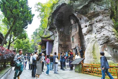 　　5月1日，游客在资阳市安岳县圆觉洞摩崖石窟景区观赏石刻艺术，感受古代匠人的智慧与技艺。