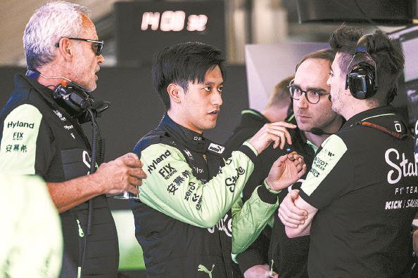 周冠宇（左二）在中国大奖赛上与车队工作人员交流 本报记者 李铭珅 摄