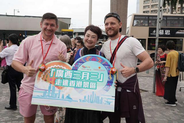 来港外国游客近距离感受“广西三月三”民俗展演后，与演员合影。活动主办方供图