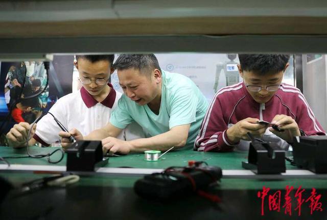 5月8日，北京中学东坝南校区，课后，科技社团的同学们在老师的指导下制作手机。中青报·中青网记者 陈剑/摄