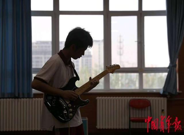 5月8日，北京中学东坝南校区，课后，高二年级的李学桥在练习电吉他。中青报·中青网记者 陈剑/摄