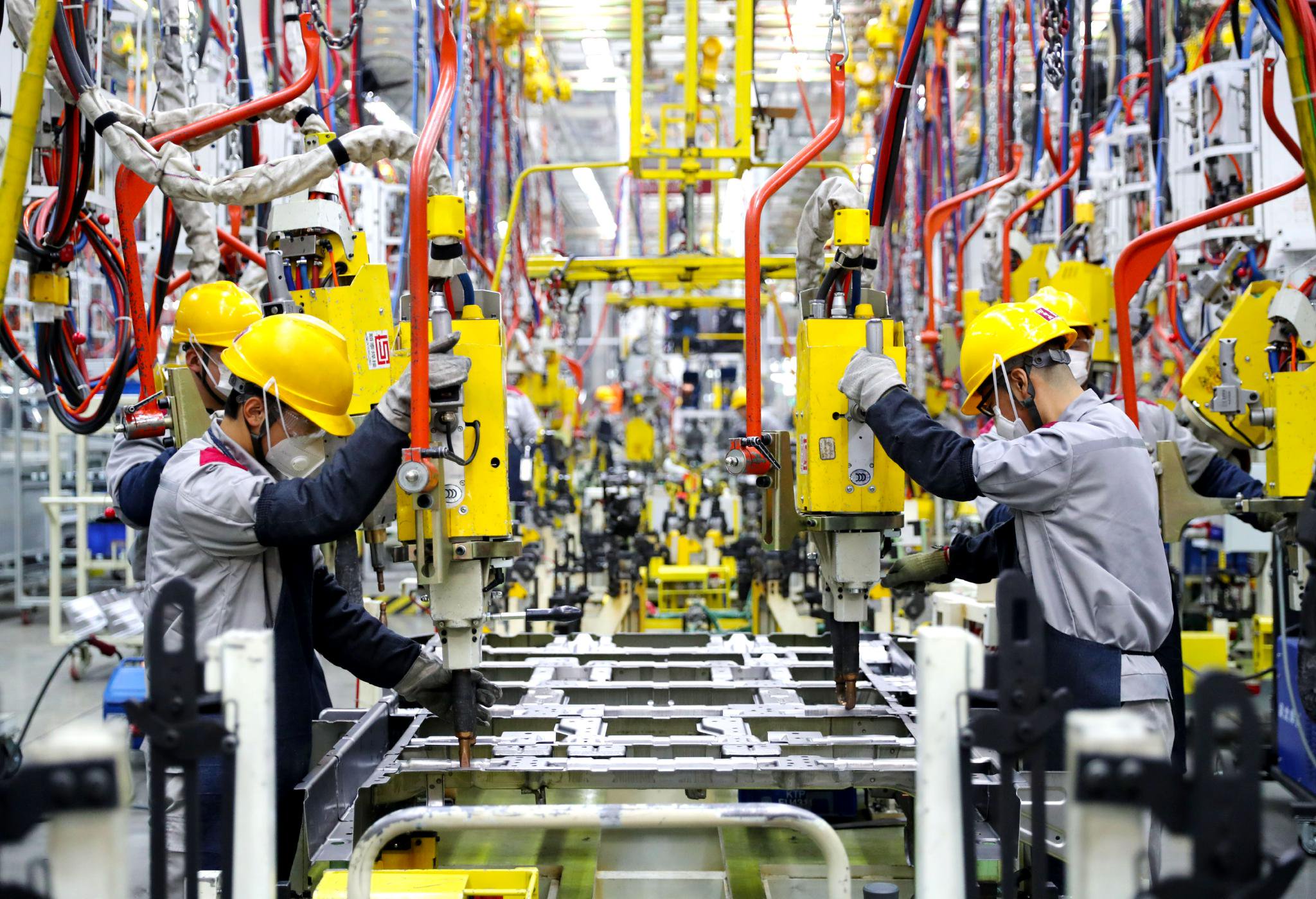 北京汽车制造厂青岛总部基地的生产车间里，工人在进行焊接作业。张进刚 摄
