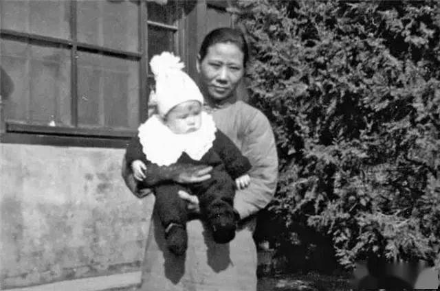 ● 1938年，李忆祖被养母抱着在家中留影