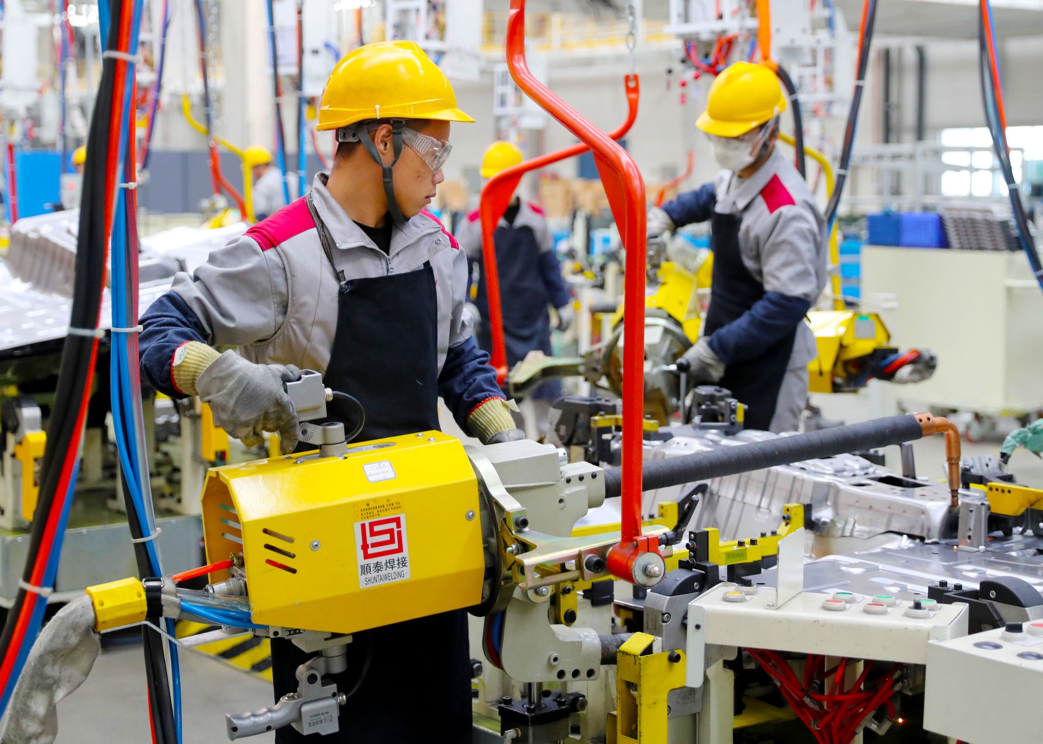 北京汽车制造厂青岛总部基地的生产车间里，工人在进行焊接作业。张进刚 摄
