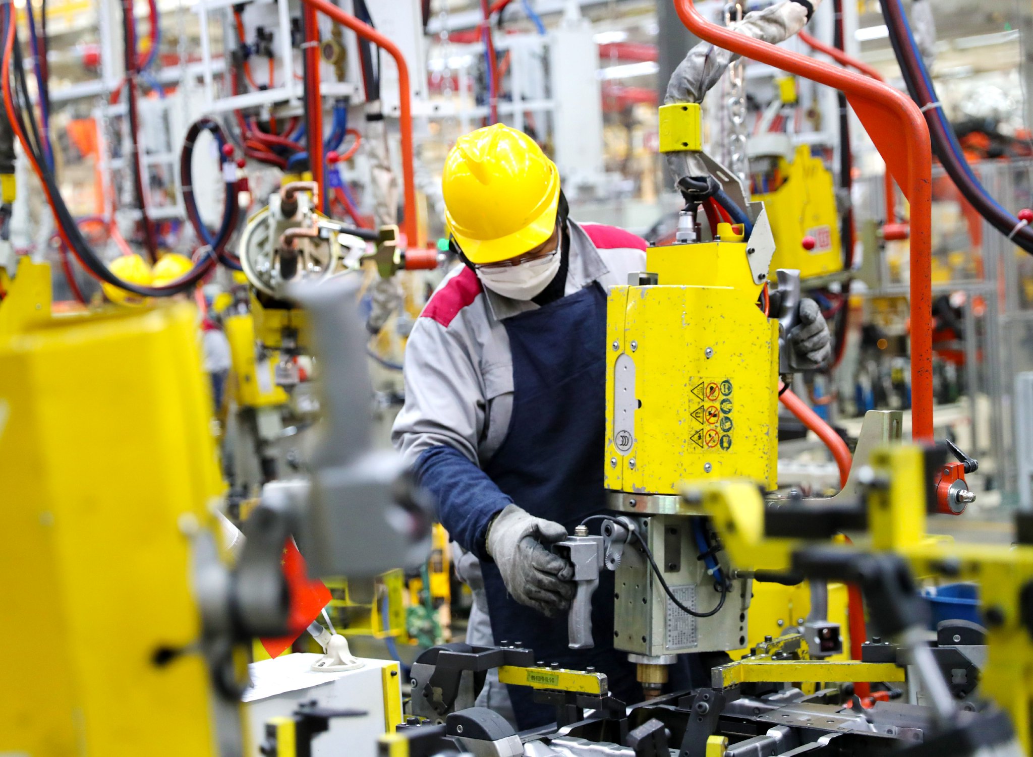 北京汽车制造厂青岛总部基地的生产车间里,工人在进行焊接作业.