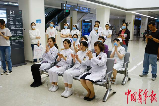 5月11日，北京协和医院西单院区门诊大厅，一名患者正在观看演出。田嘉硕/摄