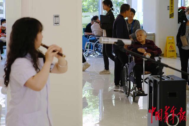 5月11日，北京协和医院西单院区门诊大厅，一名患者正在观看演出。田嘉硕/摄