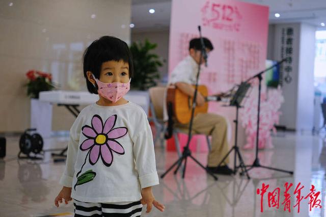 5月11日，北京协和医院西单院区门诊大厅，一名观看演出的小朋友。田嘉硕/摄