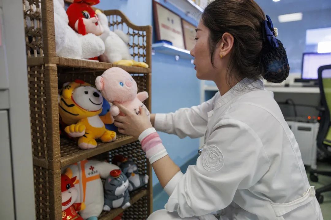▲4月23日，安定医院精神科护士郭新月在护士站摆放玩偶，这是为了缓解患者情绪放置的。新京报记者 王子诚 摄
