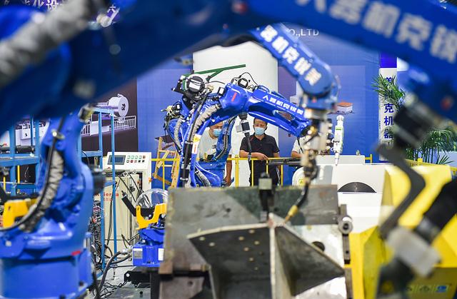2020年9月25日，观众在2020洛阳国际机器人展上参观一款工业焊接机器人。视觉中国 资料图