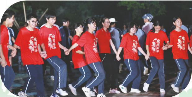 ▶南宁市五一西路学校举办毕业班心理减压篝火晚会，学生们牵手共舞。（韦桂喜 摄）