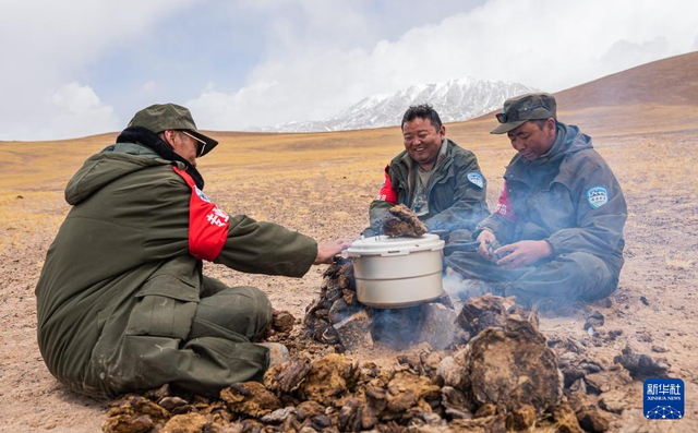 野生动物专业管护队员在巡护途中就地取材，用野牦牛粪生火做饭（5月10日摄）。新华社记者 丁增尼达 摄