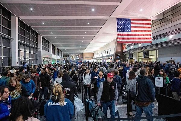 当地时间2023年12月21日，美国马萨诸塞州，旅客在波士顿洛根国际机场A航站楼排队等候安检。图源：视觉中国