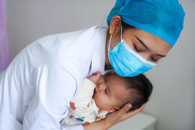 5月12日，山东淄博，高青县人民医院护士在为一名小儿哄睡。当天是国际护士节。视觉中国供图