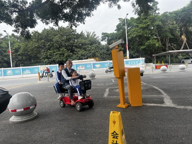 2024年春，深圳，老人骑着助动车，带着两个孩子出行。 王昀 图