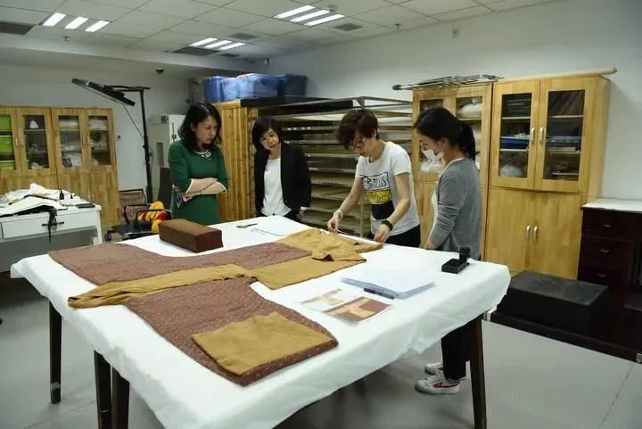 南京云锦研究所文物修复部主任杨冀元（右二）在湖南博物院交付此次的仿制品。（受访者供图） 