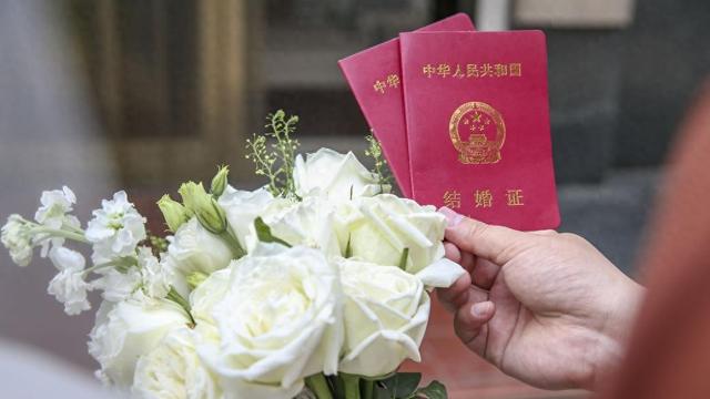 2024年5月20日,山西省运城市稷山县民政局,一对新人手捧鲜花和结婚证.