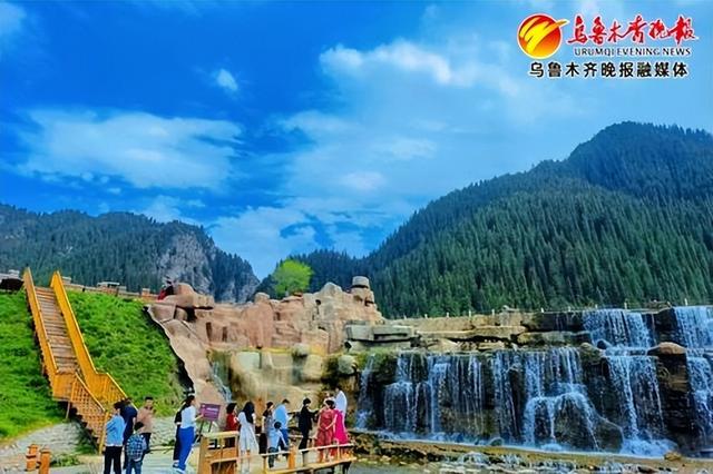 5月19日,在乌鲁木齐县天山大峡谷景区碧龙湾景点,游客在瀑布前拍照
