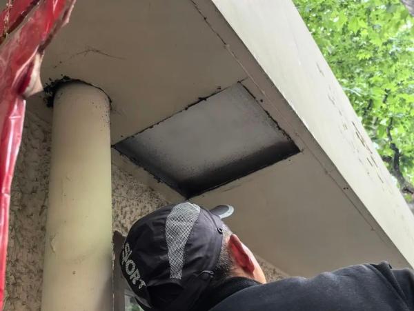 拆除门头上预留的检修孔后，记者看到里面露出的是房屋原本的挑空水泥屋檐，并不是常见的中空钢结构。