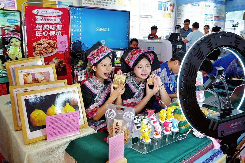 在南宁市第四职业技术学校展位,学生展示创意民族服饰.