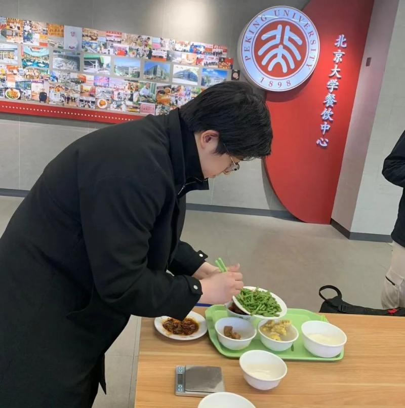 在北大食堂，老师带着学生们通过称重计算食物热量