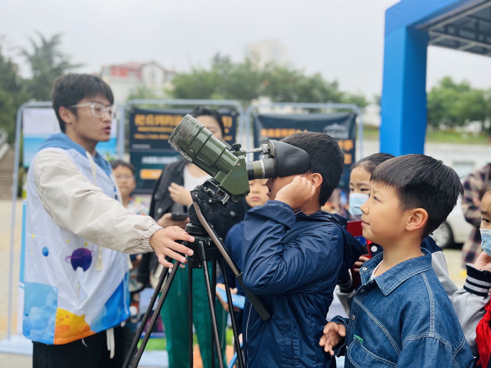 5月25日，在青岛市市南区，小朋友体验望远镜。宋迎迎 摄