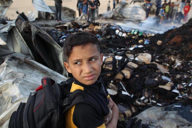 5月27日，一名男孩在加沙地带南部城市拉法查看以军轰炸后的难民营废墟。新华社发（哈立德·奥马尔摄）