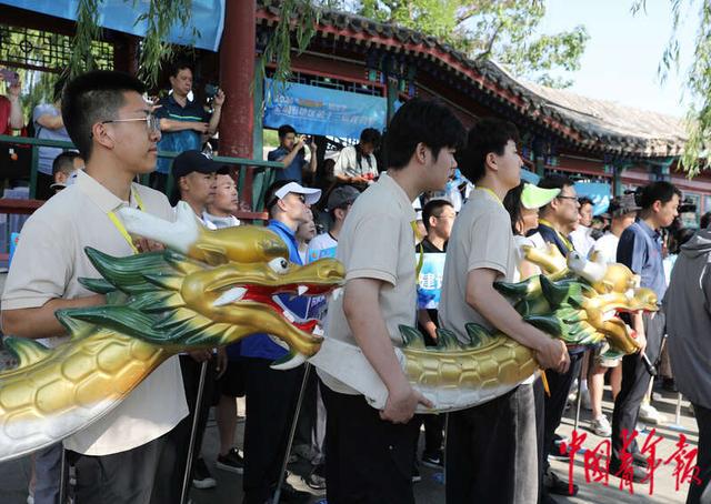 5月28日,北京什刹海,龙舟赛开始前,工作人员抱着"龙头"在开赛仪式上.