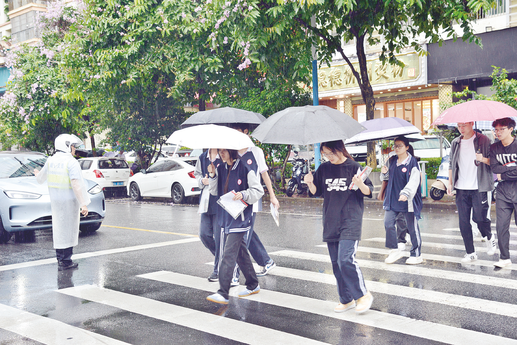 6月8日下午,在南宁市第二十九中学考点门口,交警在雨中指挥车辆,让