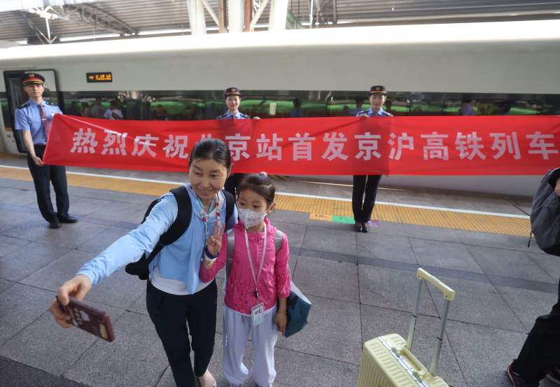 6月15日，北京站，首发京沪高铁G3次列车旅客在列车前合影留念。  新京报记者 王贵彬 摄