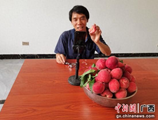 近日，在家中直播的文桂元向网友展示新鲜的桃子。蒋人轲 摄