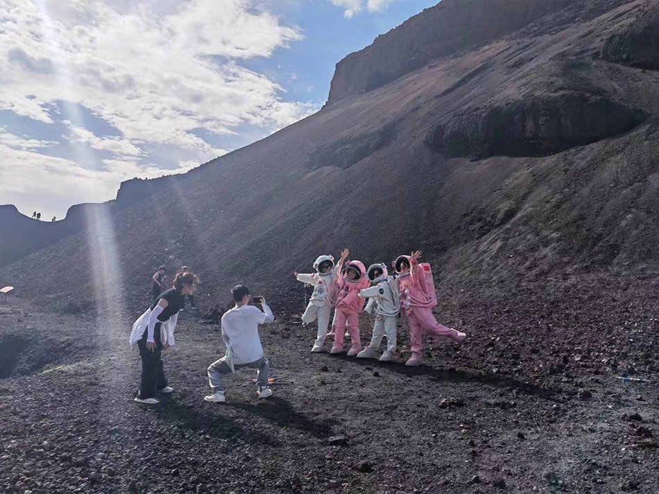 游客在火山口拍摄航空服照。 澎湃新闻记者 谭君 图